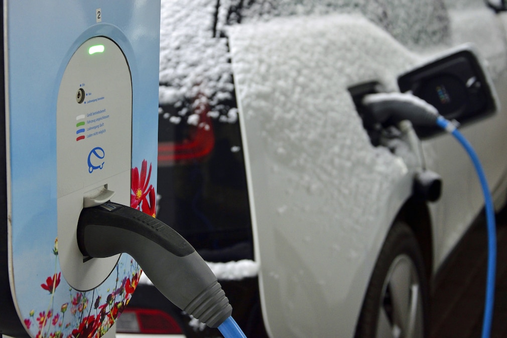 Elektroauto mit Schnee an der Ladestation