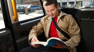 Lesen und Füße auf Armaturenbrett während der Autofahrt