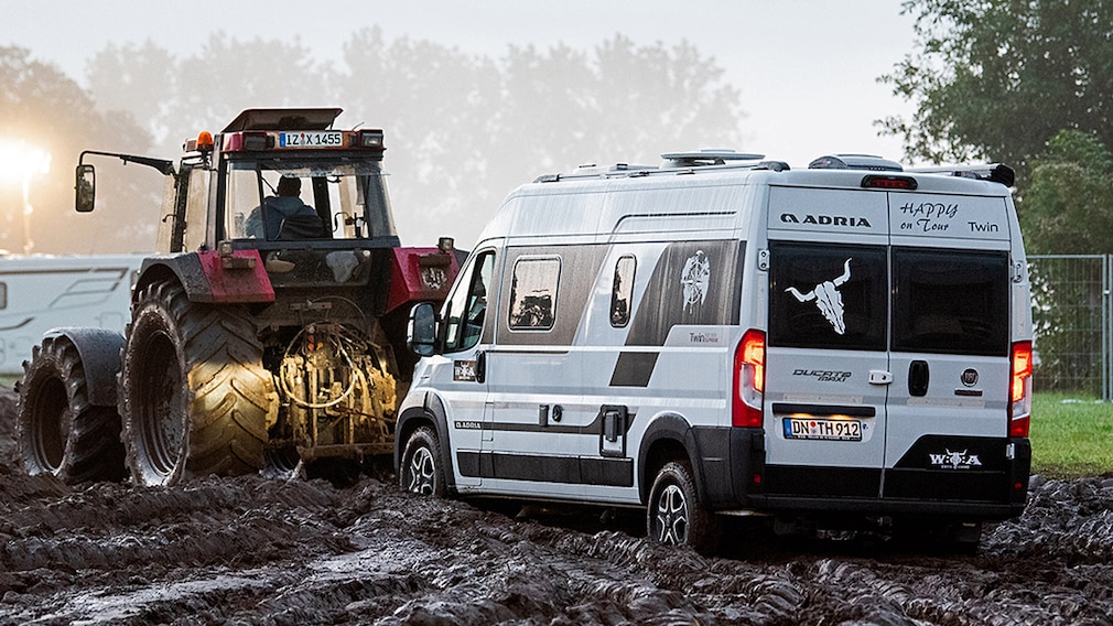 Kastenwagen wird beim Heavy-Metal-Festivals in Wacken durch den Schlamm gezogen