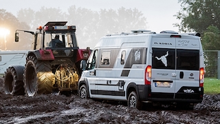 Kastenwagen wird beim Heavy-Metal-Festivals in Wacken durch den Schlamm gezogen