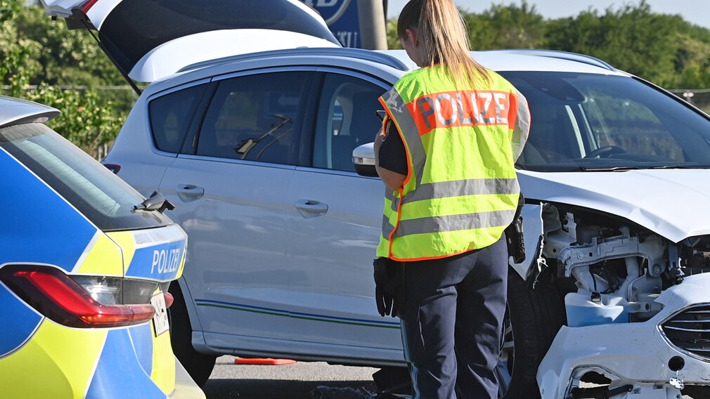 Polizistin bei der Unfallaufnahme nach Verkehrsunfall.
