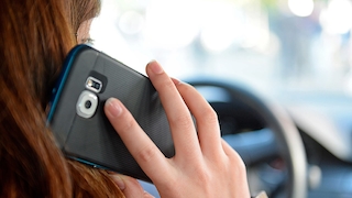 Eine Frau sitzt am 02.10.2015 in Düsseldorf (Nordrhein-Westfalen) im Auto am Steuer und telefoniert mit ihrem Smartphone. Bei einem Pressetermin informierte der nordrhein-westfälische Innenminister über die Gefahren von Handy- und Smartphonenutzung am Steuer.