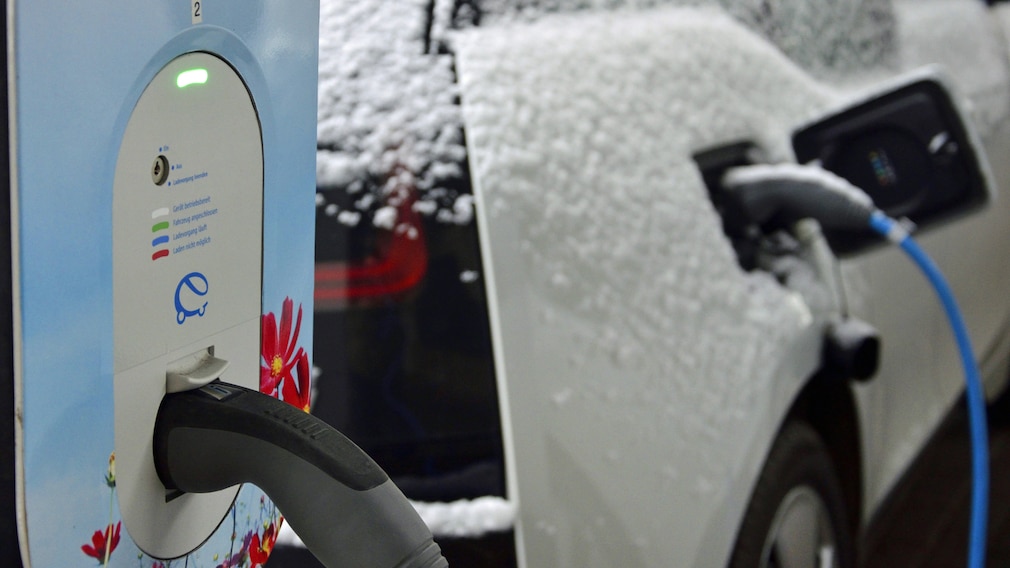 Elektroauto mit Schnee an der Ladestation