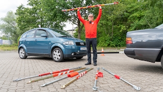Redakteur auf Aufmacherbild mit allen Abschleppstangen vor zwei Autos positiioniert.