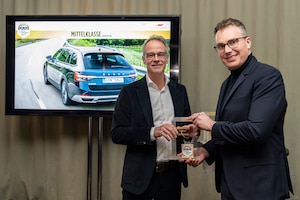 Jörn Sebening von Škoda Auto Deutschland nimmt die Auszeichnung von Robin Hornig entgegen