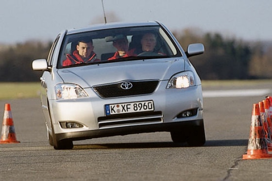 Ein schwarzer toyota corolla ist auf der straße vor einer