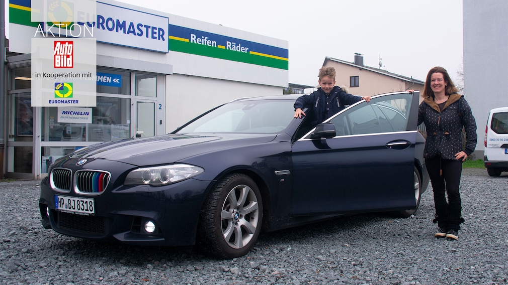 Frau Eberts mit Sohn Johnathan und ihrem reparaturbedürftigem BMW 5er