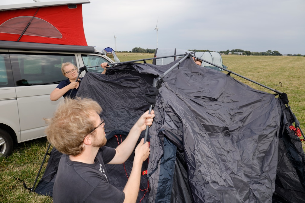 Die AUTO BILD Tester montieren eine Zeltplane inkl. Gestänke der Vorzelte