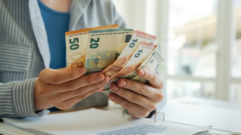 Zwei Hände mit Euro-Scheinen