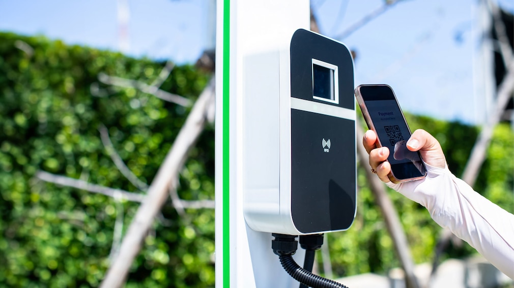 E-Ladesäule und Person mit Smartphone