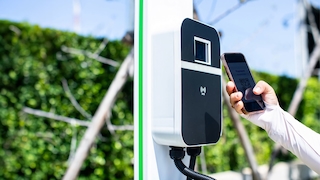 E-Ladesäule und Person mit Smartphone