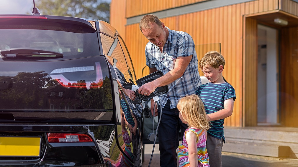 BMW i3 - Vater und Kinder laden Elektroauto auf