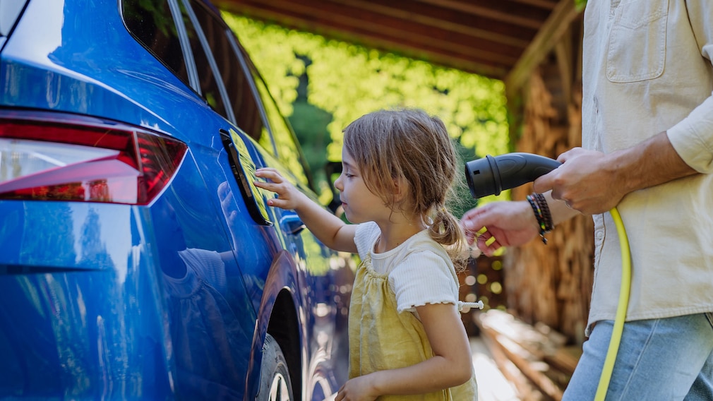 Erwachsener und Kind an einem E-Auto