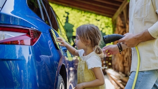 Erwachsener und Kind an einem E-Auto