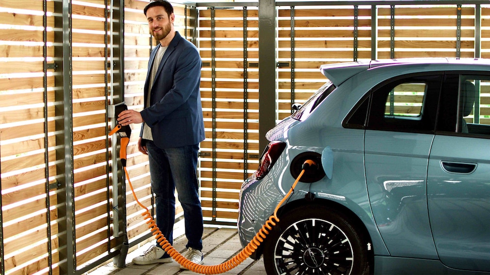Person lädt E-Auto an Ladesäule