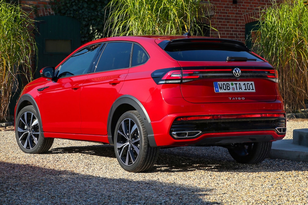 VW Taigo R Line in Rot steht schräg von hinten vor einem Fachwerkgebäude.
