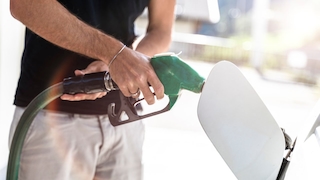 Ein Mann Tankt sein Auto an einer Zapfsäule an einer Tankstelle - Symbolbild Tanken