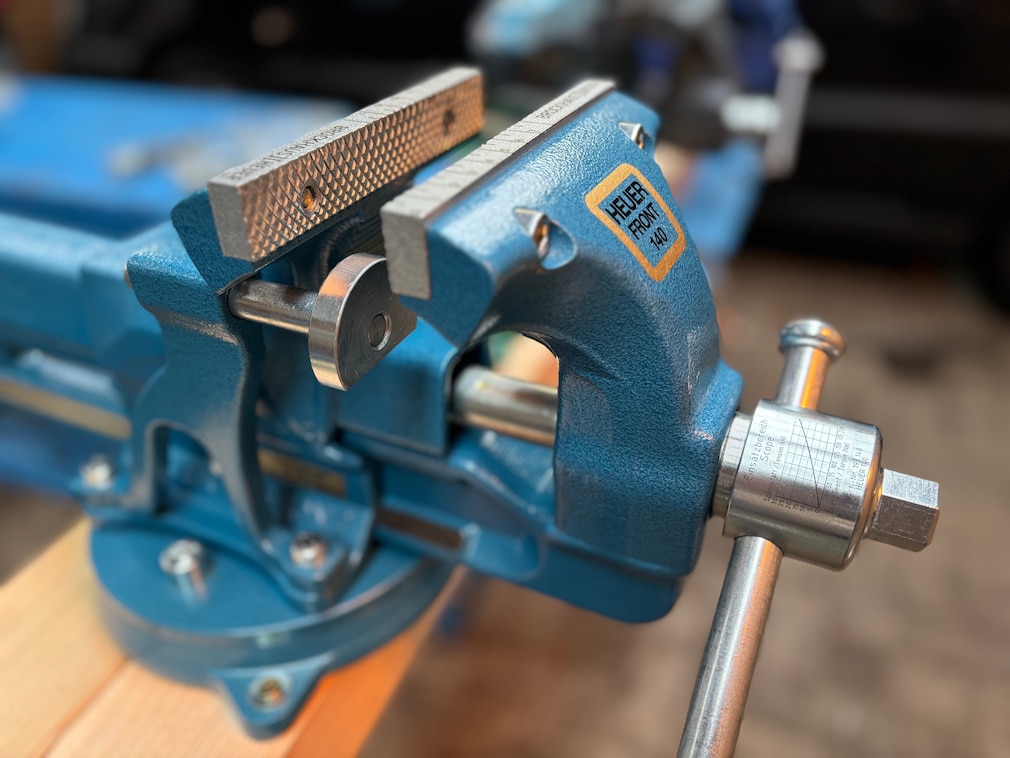 Perspektivische Seitenansicht des Heuer-Schraubstocks in Werkstattumgebung.