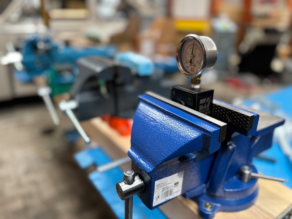 Testsituation: Ein Druckmessgerät zur Ermittlung der Klemmkraft, eingespannt in einem Schraubstock.