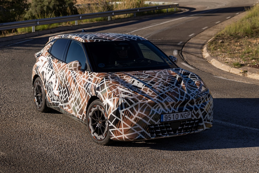 Getarnter Cupra Raval steht auf einer kurvigen Landstraße.