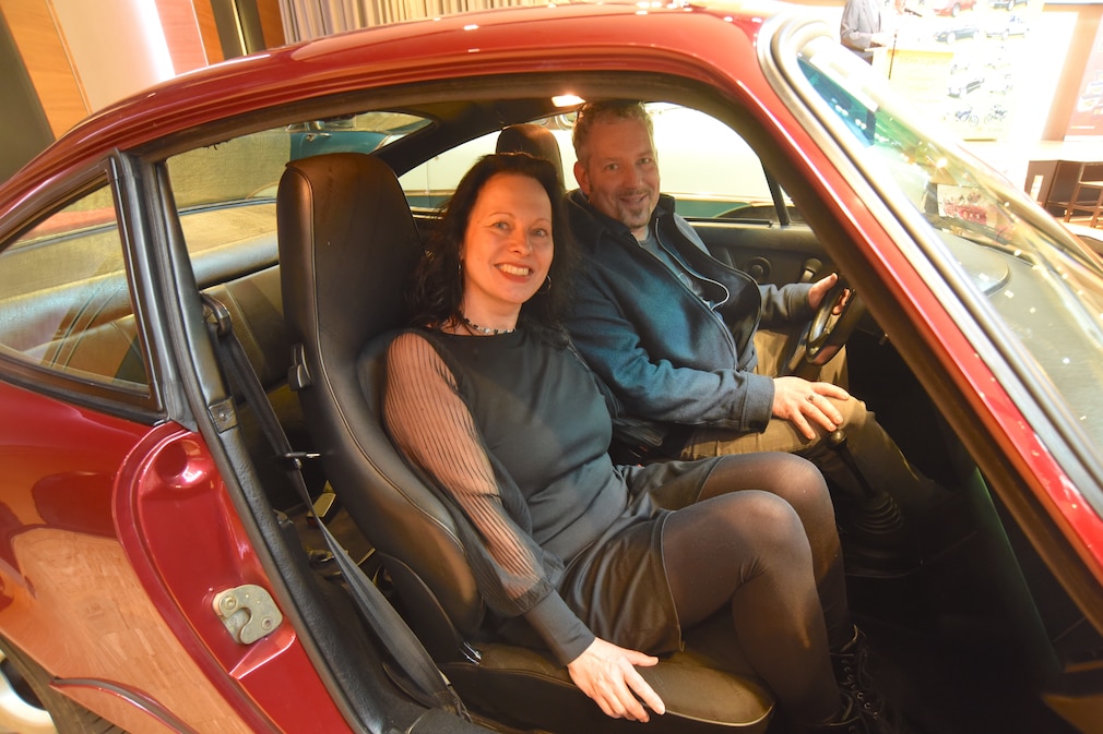 Moni Staudter sitzt im Porsche 911 auf dem Beifahrersitz, ihr Mann am Steuer.