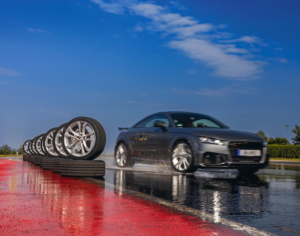 Audi TT fährt an aufgereihten Test-Reifen vorbei
