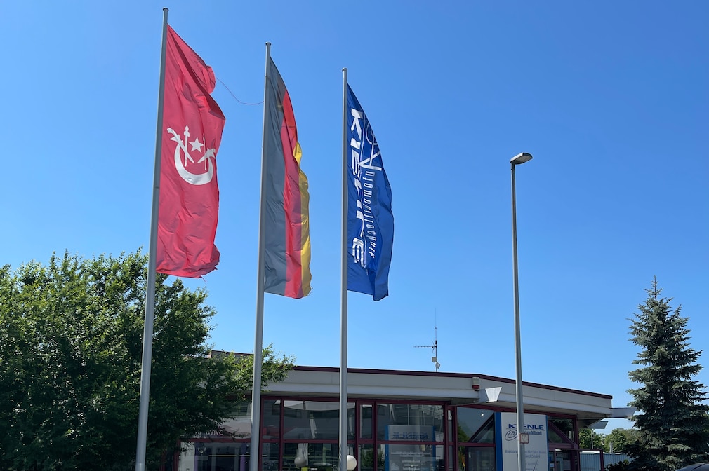 Drei Flaggen vor Kienles Autohaus, darunter eine Kienle-Flagge