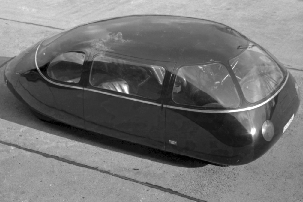 Schwarzweißfotos eines Autos, dessen Außenhaut sehr glatt und rund ist.