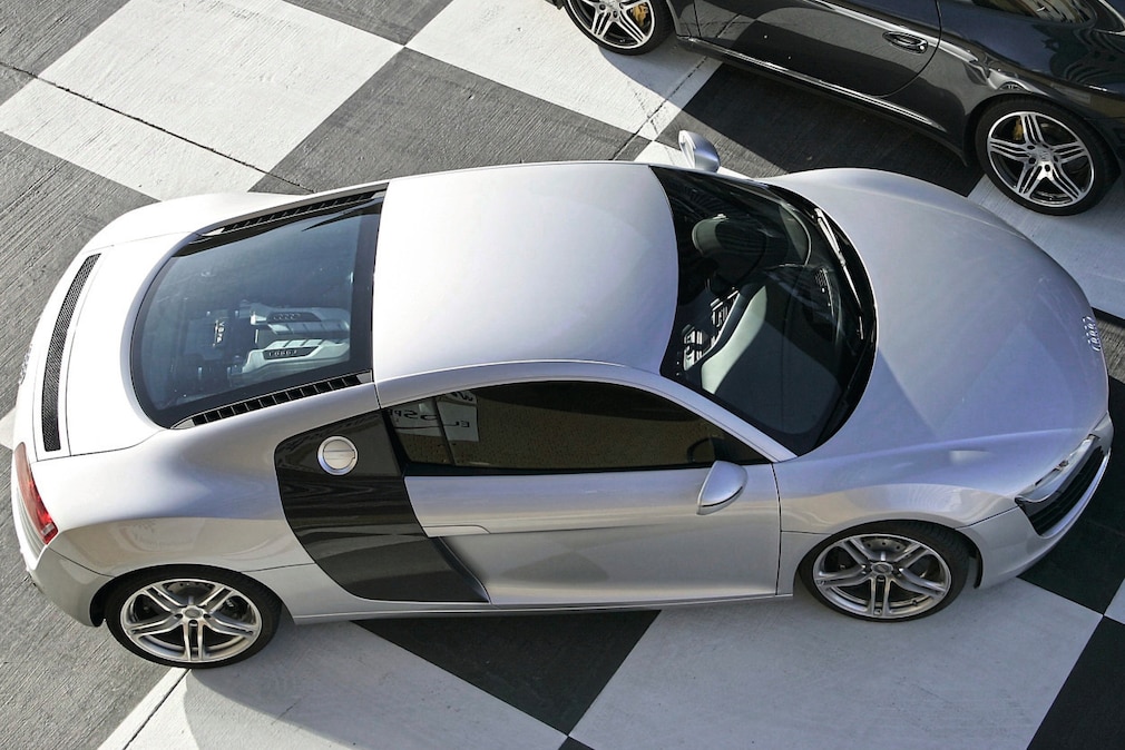 Audi R8, seitlich von schräg oben fotografiert, so dass man den Mittelmotor unter der Glaskuppel sieht