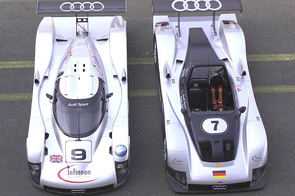 Zwei Rennwagen steil von oben: links ein Coupé mit geschlossener, rechts ein Roadster mit offener Karosserie