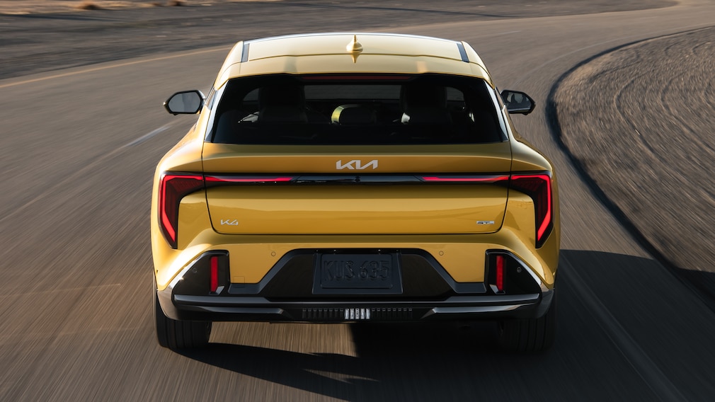 Kia K4 Hatchback fahrend in der Heckansicht.