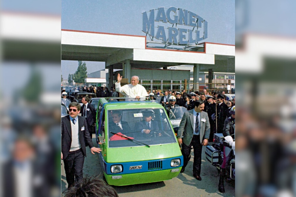 historisches Foto: Papstbesuch bei Magneti Marelli, Johannes Paul II. winkt aus dem Bertone-Bus heraus