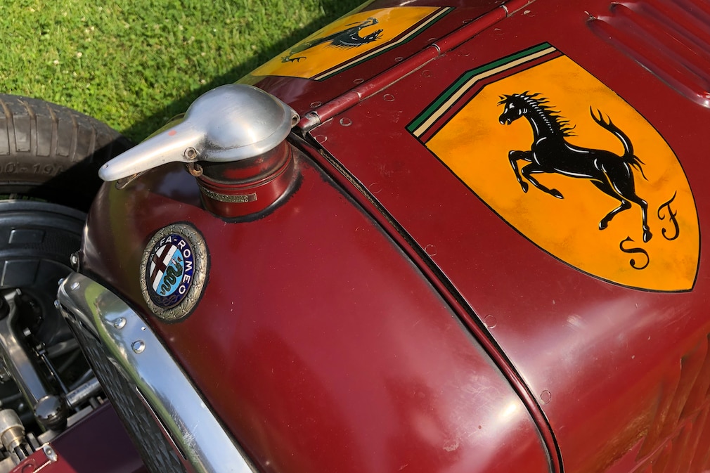 Ferrari-Logo auf der Motorhaube eines Alfa-Romeo-Rennwagens, nahe dem Alfa-Romeo-Logo
