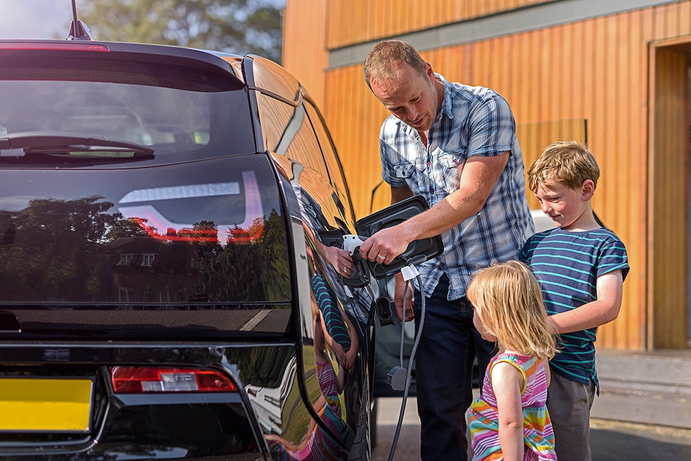 BMW i3 - Vater und Kinder laden Elektroauto auf