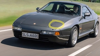 Porsche 928 Flachbau mit konventionellen Klappscheinwerfern fahrend von schräg vorn
