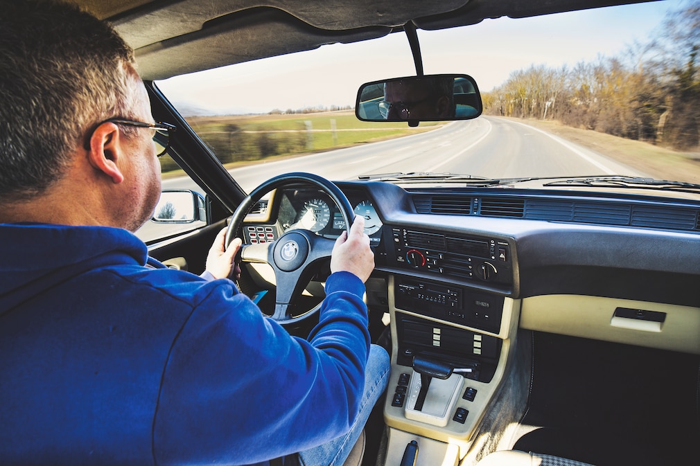 Redakteur beim Fahren des BMW 628 CSi schräg von hinten, Blick aufs Cockpit