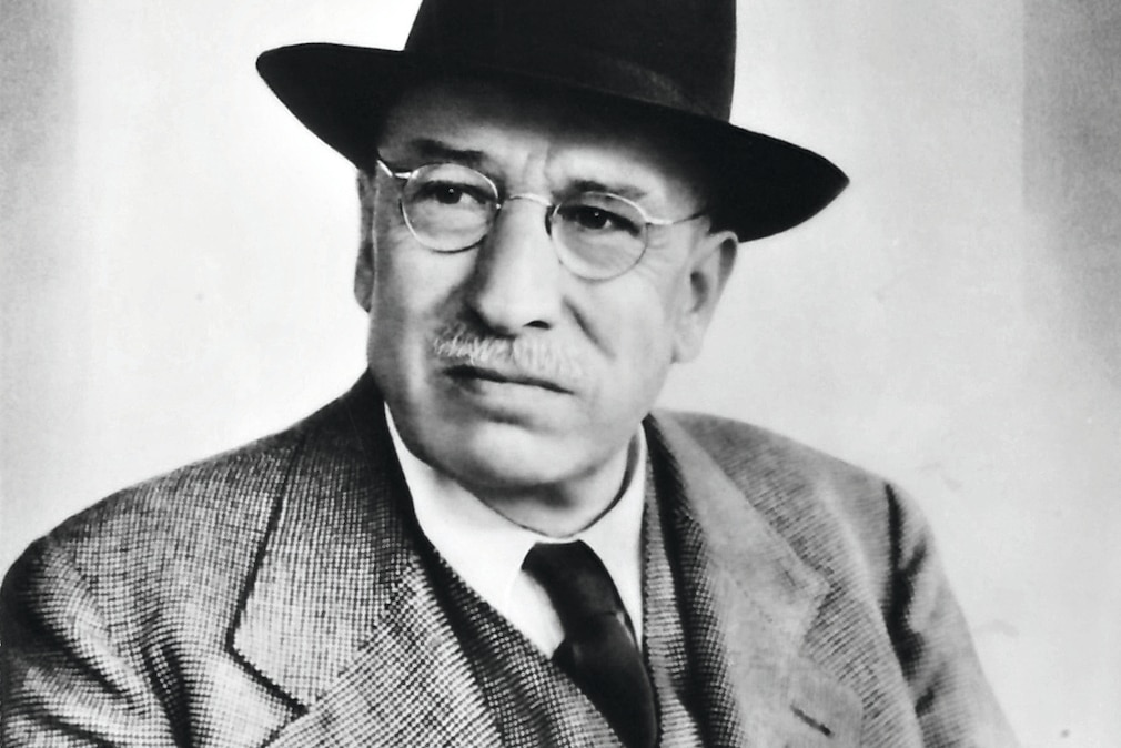 Schwarzweiß-Portraitfoto von Ernst Hahn, einem Herrn mit Hut, Brille, hellem Schnauzbart und dreiteiligem Anzug.