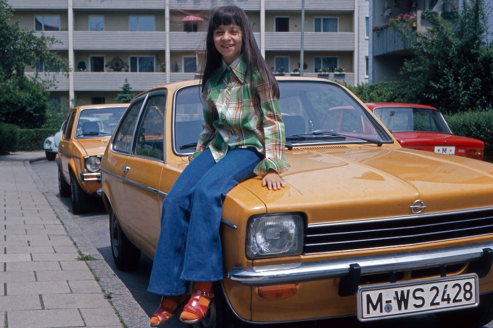 Historisches Foto aus den 70er-Jahren: Mädchen sitzt auf Kotflügel eines Opel Kadett C City