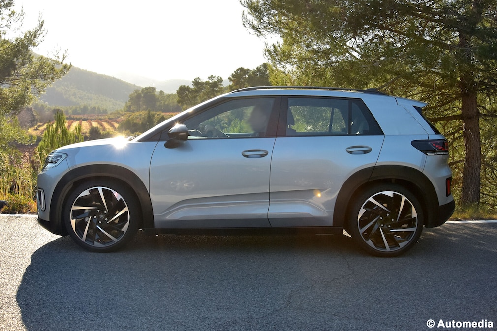 Kaum getarnter VW ID. Cross Prototyp fährt auf einer Landstraße vorbei.