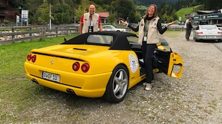 Gelber Ferrari F355 F1 Spider stehend von schräg hinten mit ihren Besitzern
