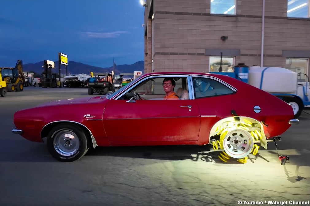 Fahrender Ford Pinto im Profil mit Hinterrad aus Federn