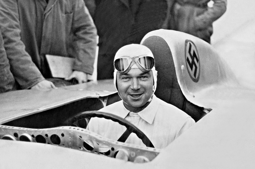 historisches Schwarzweißfoto: Rudolf Caracciola 1936 in seinem Mercedes-Benz-Rennwagen mit Hakenkreuz