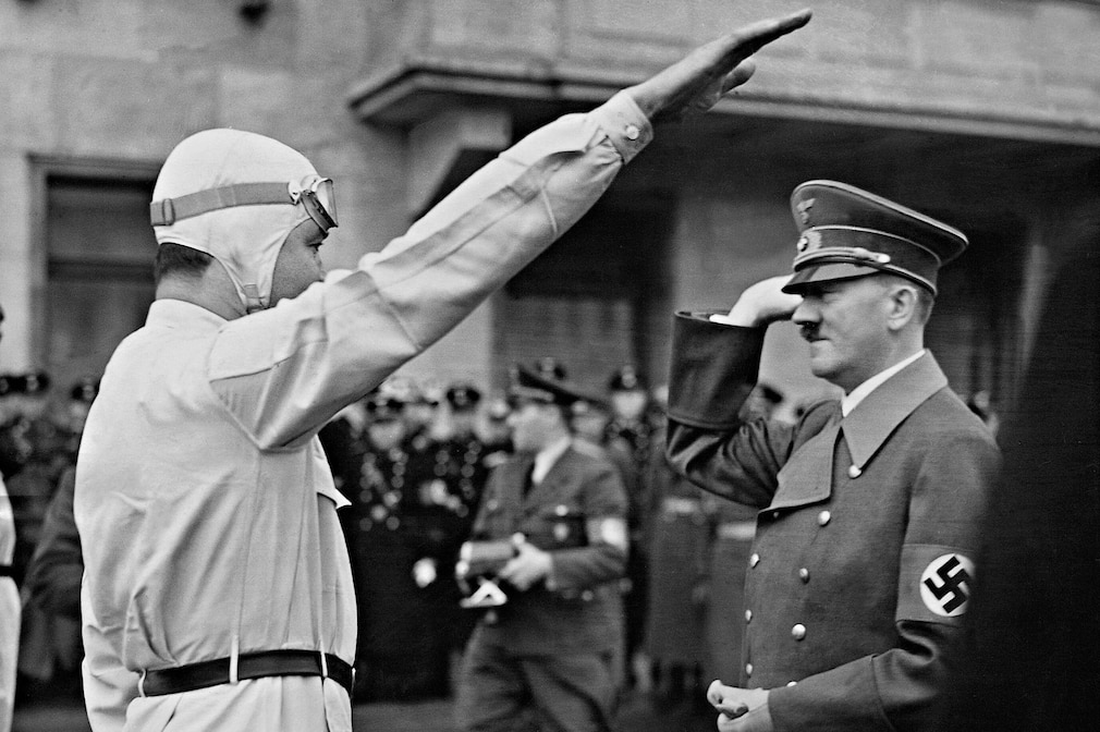 historisches Schwarzweißfoto: Rudolf Caracciola macht Hitlergruß vor Adolf Hitler