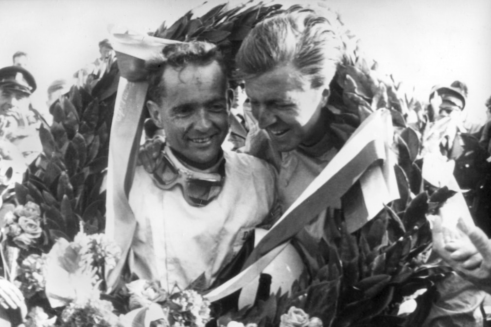 historisches Schwarzweißfoto: Wolfgang Graf Berghe von Trips im Siegerkranz mit Phil Hill