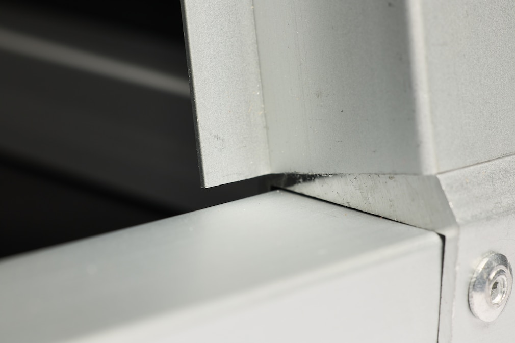 Nahaufnahme einer Alu-Box mit Blick auf die Verarbeitungsmängel, hier die scharfkantige Alu-Profil-Verbindung.