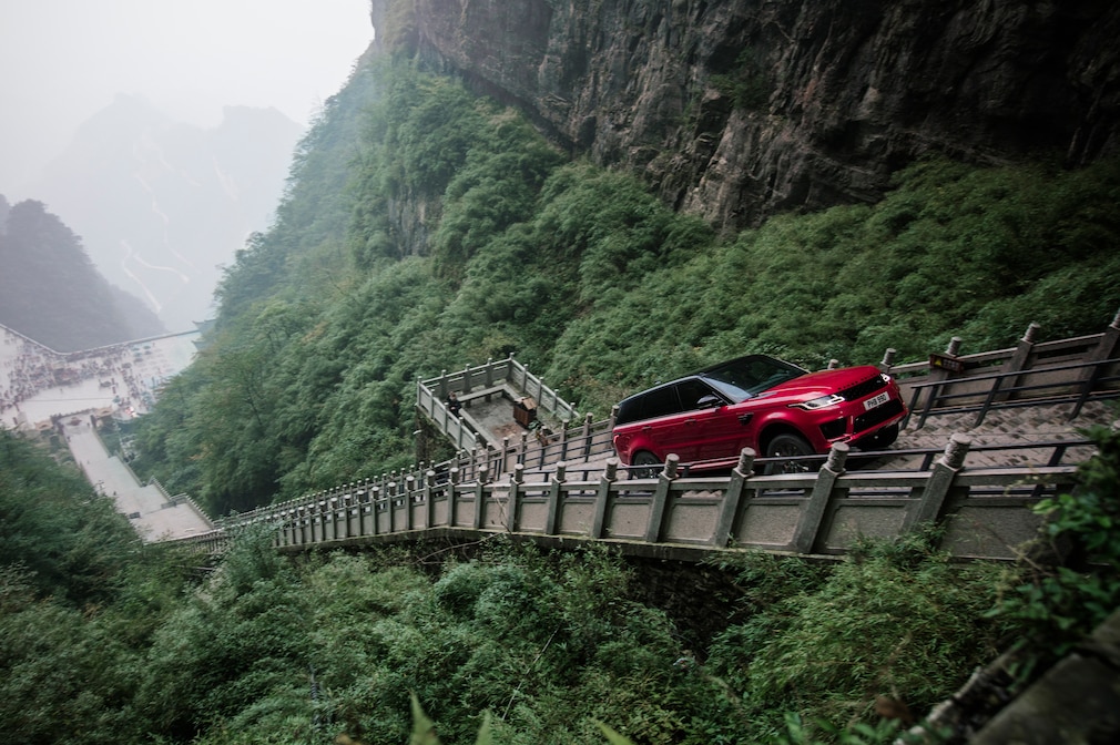 Roter Range Rover Sport fährt die steile Himmelsleiter am Tianmen-Berg in China hinauf.