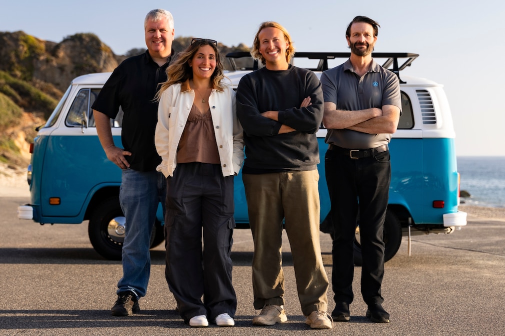 Vier Personen vor dem blauen VW Bus T2 T2b Bulli