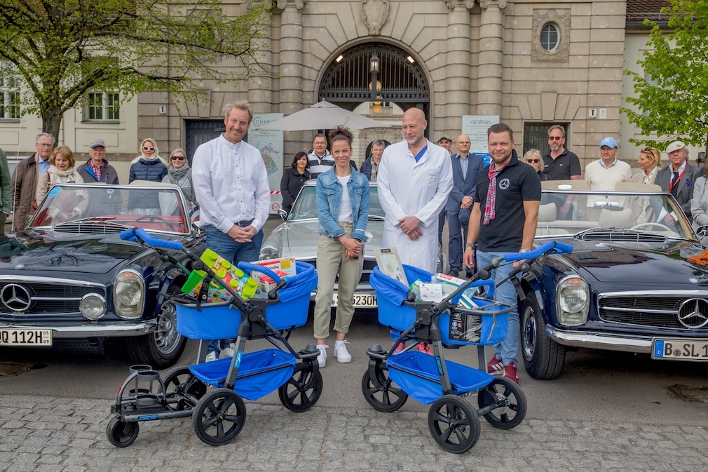 Spendenübergabe mit Mercedes SL Pagoden, blauen Spezial-Kiunderwagen und Personen