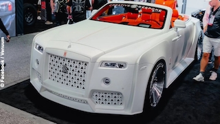 Weißer Rolls-Royce Dawn als Custom-Cabrio mit orangem Interieur auf einer Messe.