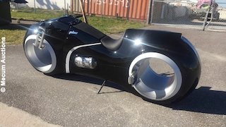 Schwarzes Motorrad im Tron-Lightcycle-Look steht im Freien.